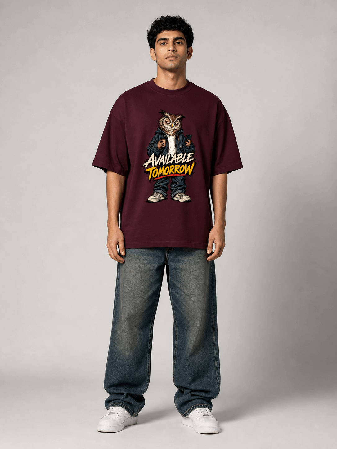 Available Tomorrow Owl maroon oversized T-shirt on Indian male model, full-length studio view