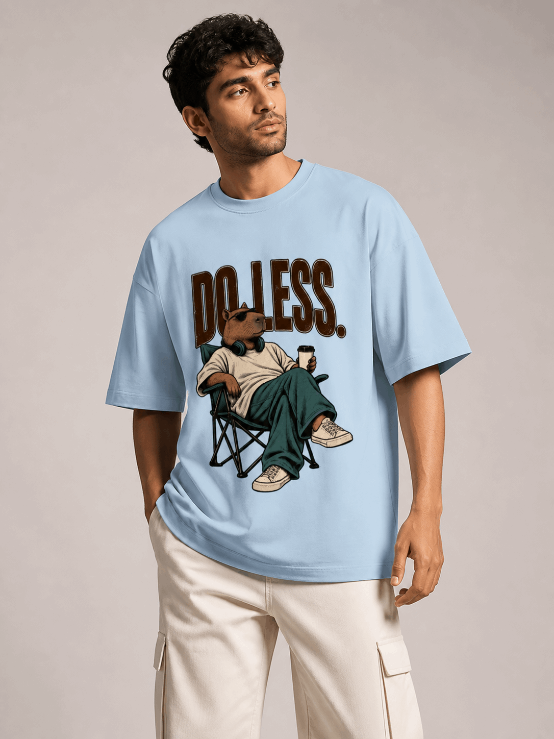 Do Less Capybara baby blue oversized T-shirt on Indian male model, three-quarter studio view