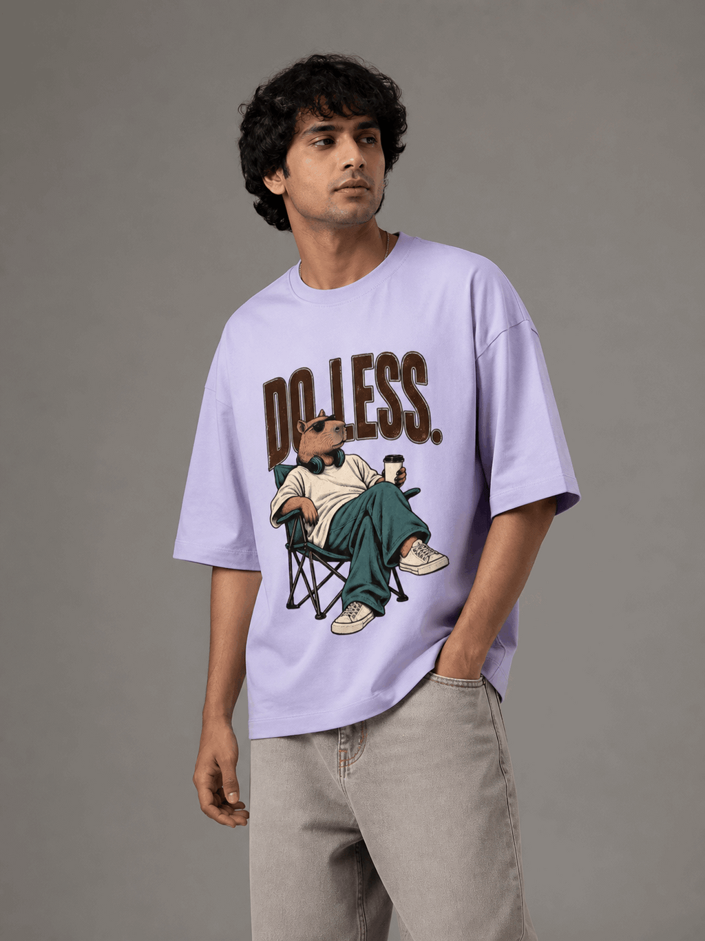 Do Less Capybara lavender oversized T-shirt on Indian male model, three-quarter studio view