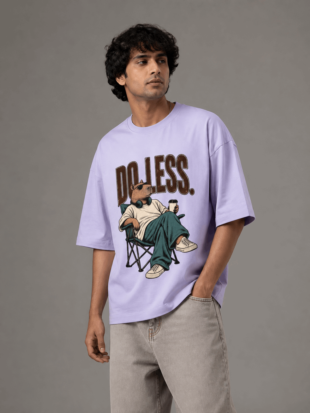 Do Less Capybara lavender oversized T-shirt on Indian male model, three-quarter studio view
