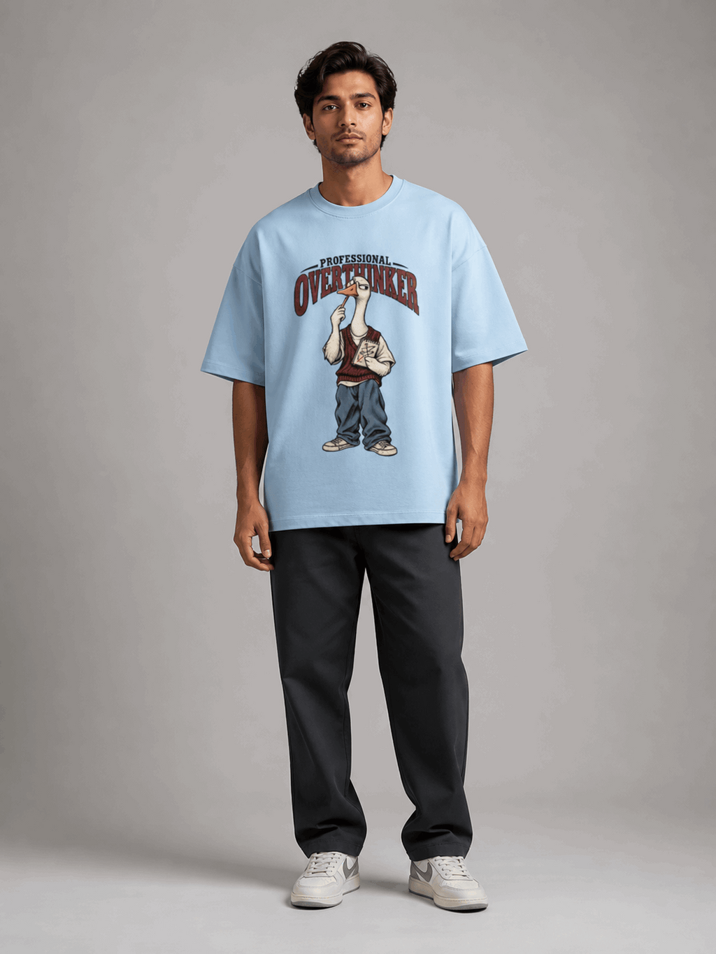 Professional Overthinker Goose baby blue oversized T-shirt on Indian male model, full-length studio view