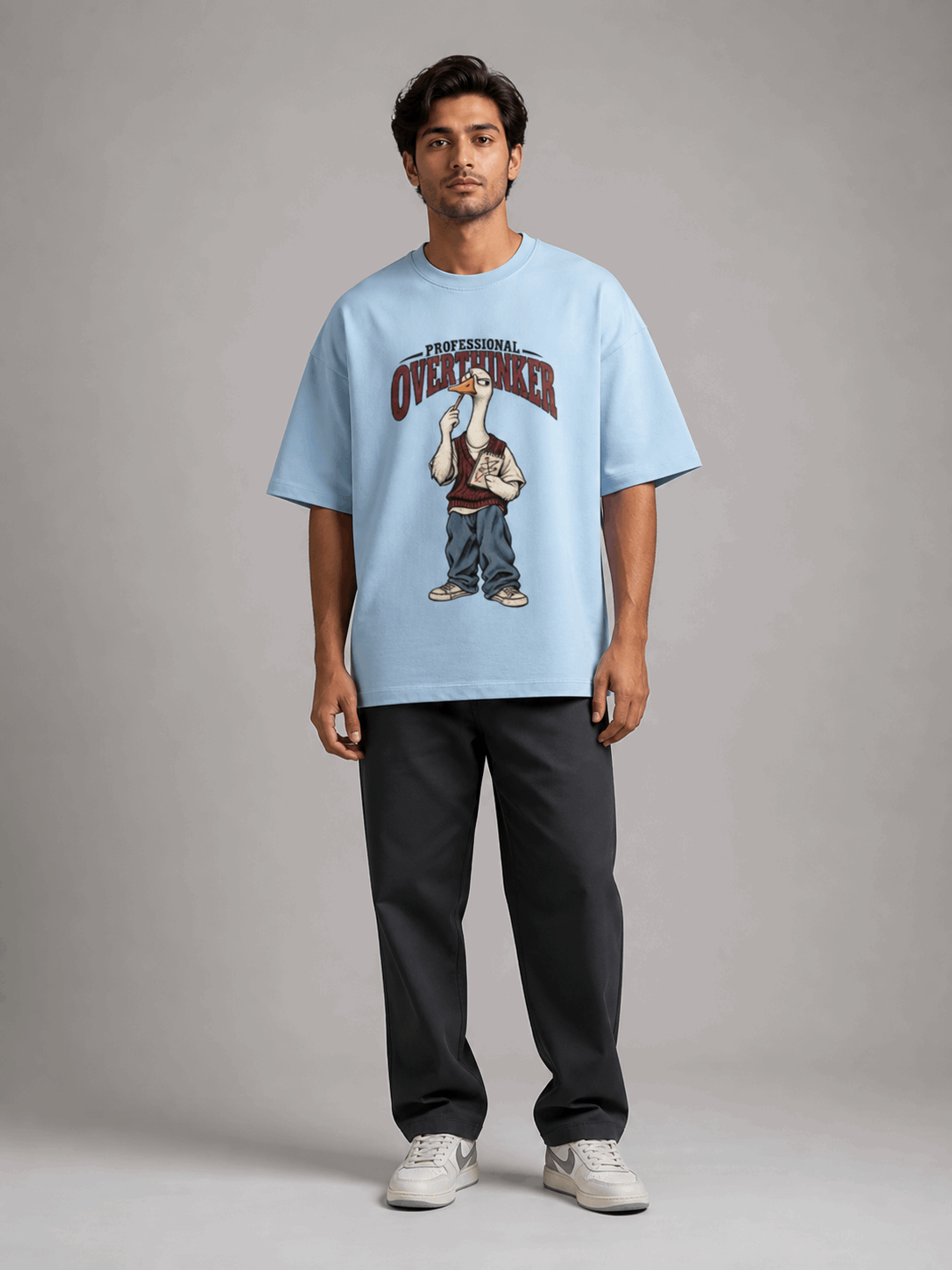 Professional Overthinker Goose baby blue oversized T-shirt on Indian male model, full-length studio view