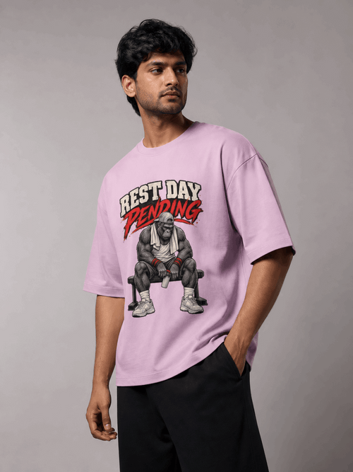 Rest Day Pending Gorilla light baby pink oversized T-shirt on Indian male model, three-quarter studio view